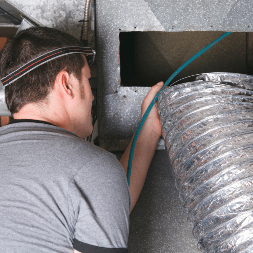 A technician working on an air duct installation, emphasizing precision and expertise in ductwork