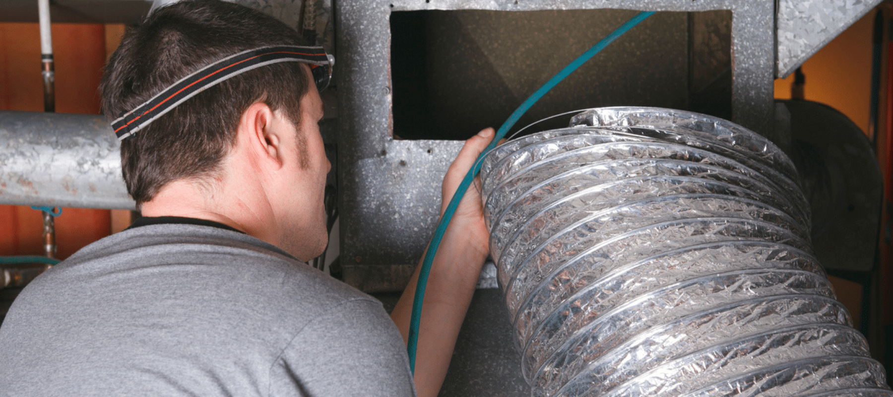 A technician working on an air duct installation, emphasizing precision and expertise in ductwork