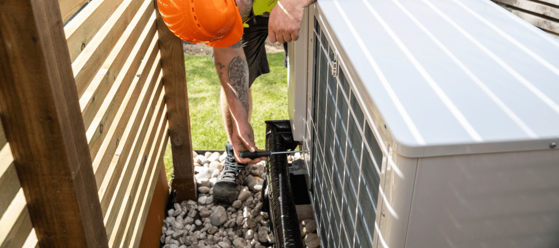 A technician in safety gear servicing an outdoor HVAC unit, showcasing professional maintenance