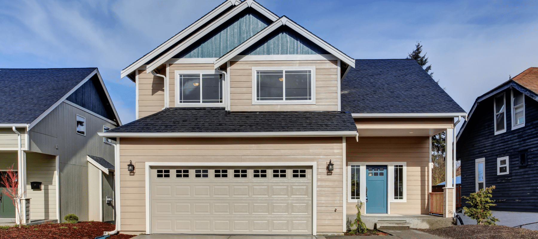 A beige two-story suburban house with a blue front door and a clean driveway